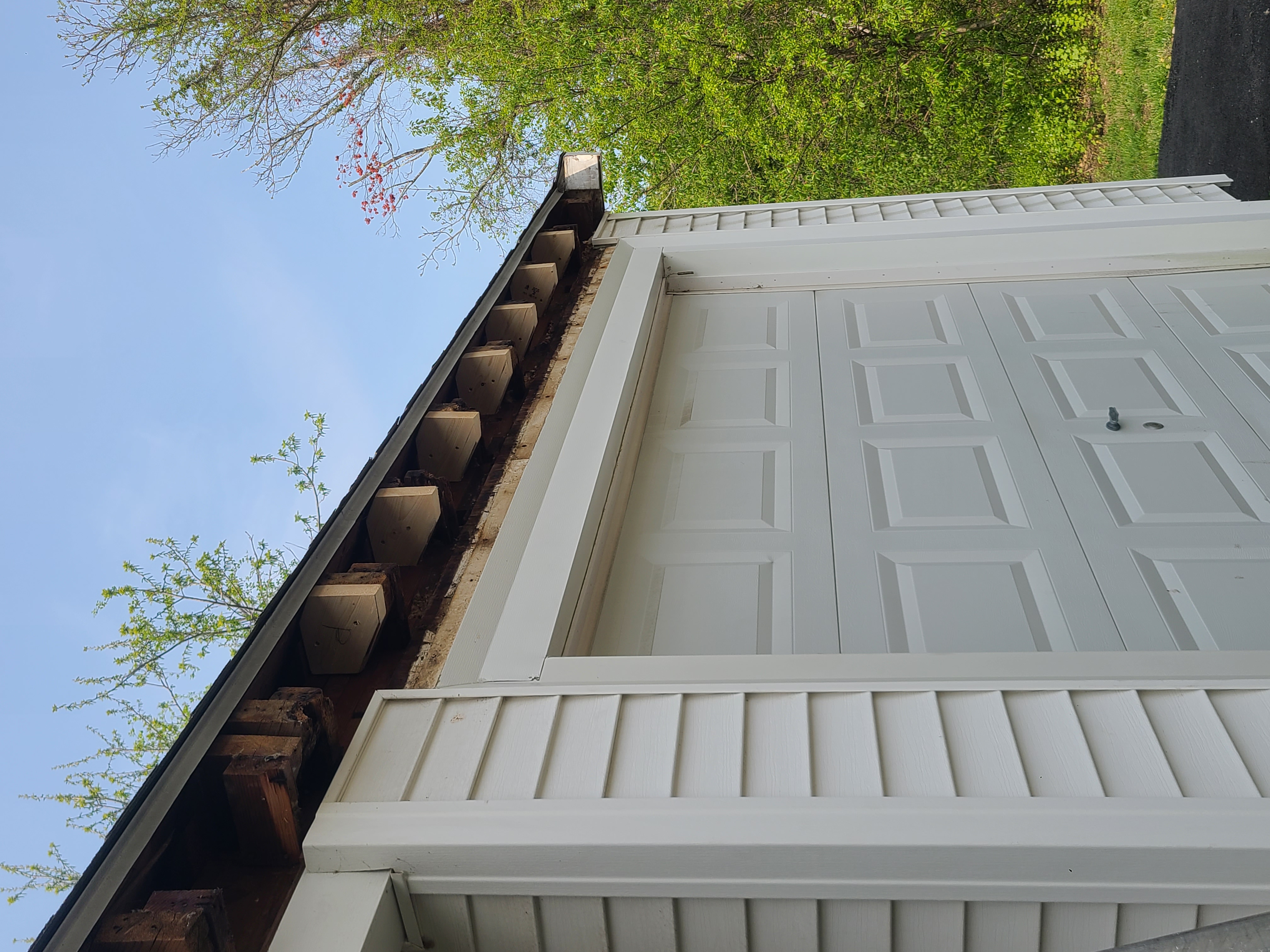 Rotted fascia exposed on garage before repair
